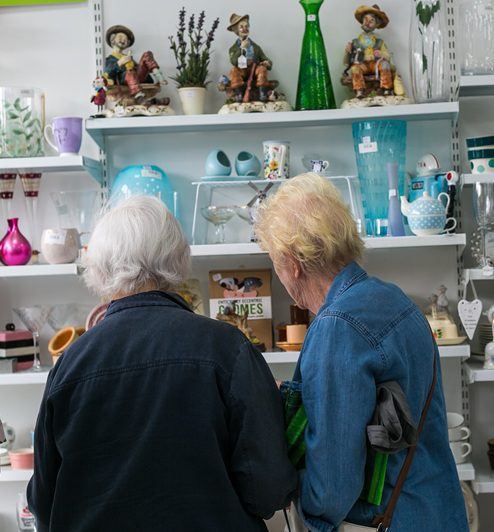 Two ladies looking at ornaments an ExtraCare charity shop